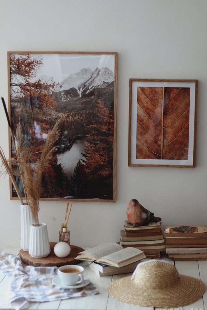 Nature-inspired framed wall art displayed above a cozy space with books, greenery, and warm earthy decor.